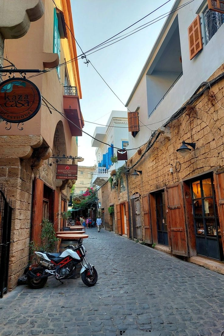 Stone houses with colorful shutters and flowers in Batroun's old town streets